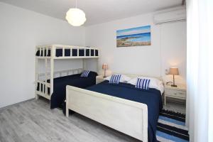 un dormitorio con dos camas y una litera en Apartments Rozanda, en Baška