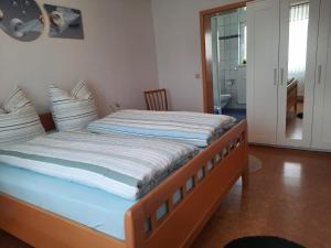 a bed with a wooden frame in a room at Ferienwohnung mit Terrasse in Insheim