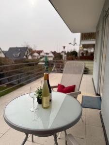 a white table with a bottle of wine and a glass at Ferienwohnung mit Terrasse in Insheim