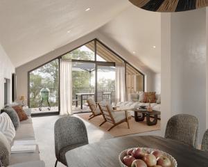 a living room with a large window and a dining room at Harz Eco Lodges in Bad Sachsa