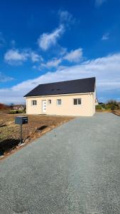 una casa bianca con un tetto nero su una strada di Gîte cosy près de la mer - Maison familial tout équipé - Côte d'Albâtre a Cany-Barville