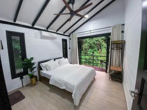 彭亨Casa Damai Janda Baik - RIVERVIEW TINY HOUSE的卧室配有白色的床和吊扇