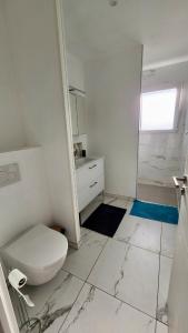 un bagno bianco con wc e doccia di Gîte cosy près de la mer - Maison familial tout équipé - Côte d'Albâtre a Cany-Barville