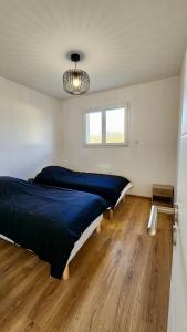 una camera da letto con un letto grande e un pavimento in legno di Gîte cosy près de la mer - Maison familial tout équipé - Côte d'Albâtre a Cany-Barville