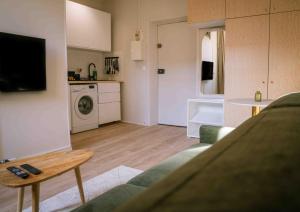 ein Wohnzimmer mit Couch und Tisch und eine Küche in der Unterkunft Le Duc d'Anjou Classé 3 étoiles Confort & Charme au cœur de ville in Versailles