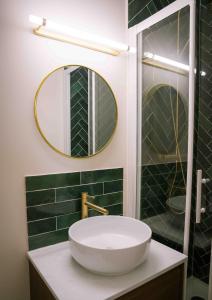 ein Badezimmer mit Waschbecken und Spiegel in der Unterkunft Le Duc d'Anjou Classé 3 étoiles Confort & Charme au cœur de ville in Versailles + 11 Fotos