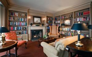 a living room with a fireplace and bookshelves at Mountain View Grand Resort & Spa in Whitefield