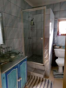 a bathroom with a shower with a sink and a toilet at Beach Cottage Pumula in Pumula +41 photos