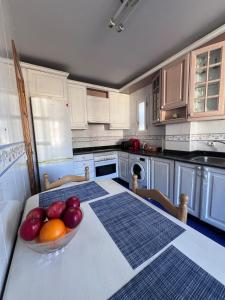 a kitchen with a bowl of fruit on a table at Casa la Plaza in Molinaseca +23 photos