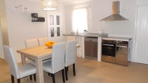 a kitchen with a wooden table and chairs in a kitchen at Casa Rural Valdezaque in Cordobilla de Lácara