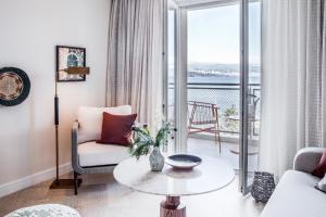 a living room with a table and a balcony at Amadria Park Grand Hotel 4 Opatijska Cvijeta in Opatija