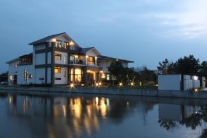 una casa junto al agua por la noche en CarNo B&B, en Yuanshan