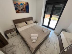 a bedroom with a bed with two towels on it at Luxury Maisonette Blue Stone in Hanioti
