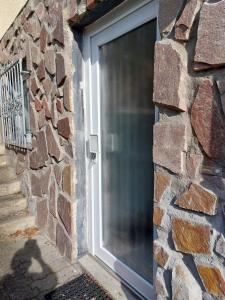 a door in a stone wall with a window at Ferienwohnung Thiel in Much