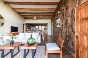 a living room with white furniture and a wooden wall at Refugio Millaray - Vistas y Acceso al Lago in Pucón