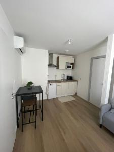 a living room with a table and a kitchen at Riedisheim Cozy in Riedisheim