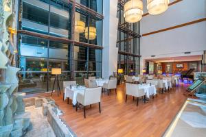 a dining room with white tables and chairs at Anemon Grand Eskişehir Otel in Eskisehir