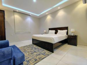 a bedroom with a bed and a blue couch at شذا المصيف لبيوت العطلات in Al Shafa