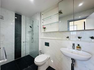 une salle de bain avec toilettes, lavabo et douche dans l'établissement Modern 3-Bedroom Apartment, Ryde NSW 2112, à Sydney 16 autres photos