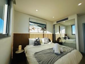 une chambre avec un grand lit et un miroir dans l'établissement Modern 3-Bedroom Apartment, Ryde NSW 2112, à Sydney
