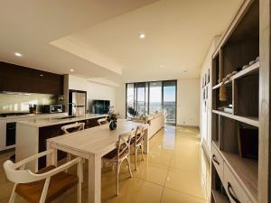 une cuisine et une salle à manger avec une table et des chaises dans l'établissement Modern 3-Bedroom Apartment, Ryde NSW 2112, à Sydney