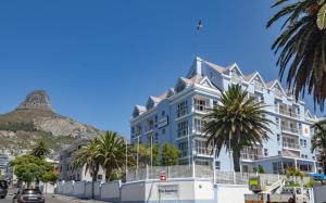 a large white building with a mountain in the background at The Bantry Aparthotel by Totalstay in Cape Town