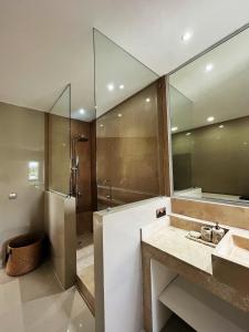 a bathroom with a shower and a sink and a mirror at Villa Aora Bingin Large 4 Bedroom Villa in Uluwatu