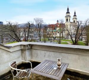 a table and chairs on a balcony with a building at Apartments Katrca Ljubljana in Ljubljana
