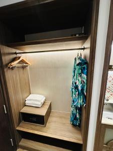 Cette chambre comprend un placard avec une étagère et une serviette. dans l'établissement Apec-Mandala - Condotel - Ocean view-ADP TOUR, à Ấp Thiẹn Ái