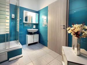 a bathroom with blue walls and a sink and a shower at Apartments Katrca Ljubljana in Ljubljana +58 photos