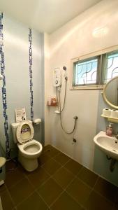 a bathroom with a toilet and a sink at Near airport cozy home in Chiang Mai