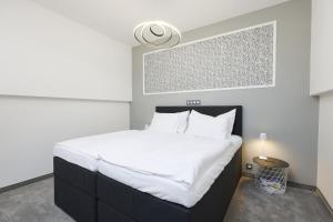 a bedroom with a large bed with white sheets at Plavírna in Otovice