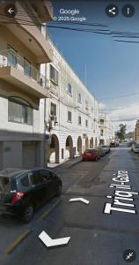 a black car parked on a street next to a building at Centrally Located Gzira in Il-Gżira