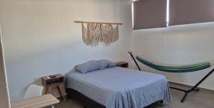 ein Zimmer mit einem Bett und einer Hängematte darin in der Unterkunft Habitación en Iker's House in Mérida