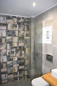 a bathroom with a glass shower with a toilet at Κalamitsi Rooms & Apartments in Kimolos +30 photos