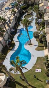 einen Luftblick auf einen Pool mit Palmen des Resorts in der Unterkunft Torrevieja - La Mata Beach First Line New Apartments 2024r in La Mata