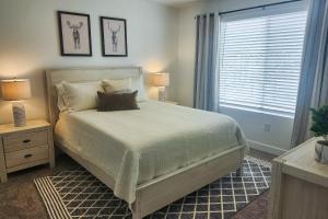 a bedroom with a bed with two lamps and a window at Cedar City Getaway in Cedar City