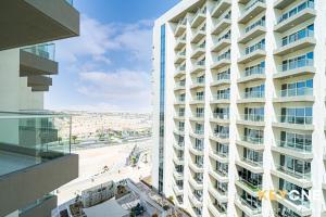 a tall white building with a view of a beach at Viridis Residence Cozy Studio Living in Dubai