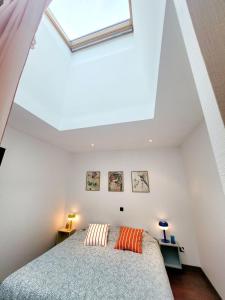 a bedroom with a bed with two pillows on it at Maison centre ville proche plage Wifi in Concarneau
