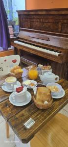 a table with plates of food and a piano at Hotel Juramento in Buenos Aires