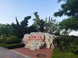 a sign on a rock in a park at Sea Pause Weihai in Weihai