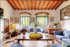 a living room with a table and blue couches at Villa Il Poggio in Greve in Chianti +15 photos