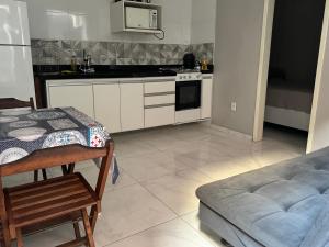une cuisine avec une table et un canapé dans l'établissement Hospedagem dos Massa- Casas no Centro de Arraial- Faça tudo a Pé!, à Arraial do Cabo