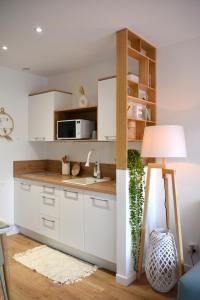 a kitchen with white cabinets and a lamp at Le Refuge du Lac in Chaumousey