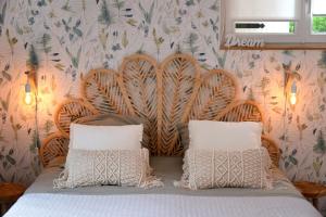 a bed with two pillows in front of a wall at Le Refuge du Lac in Chaumousey