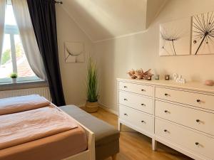 a bedroom with a bed and a dresser at Gröpernblick - Zentrumsnahe FeWo I 2 Schlafzimmer I 100 qm I Parkplätze in der Umgebung in Quedlinburg