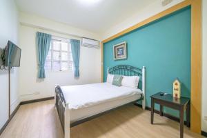 una camera da letto con un letto e una parete blu di Green Inn a Wujie