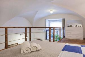 1 dormitorio con 1 cama con 2 toallas en La Salita Di San Camillo, en Catania