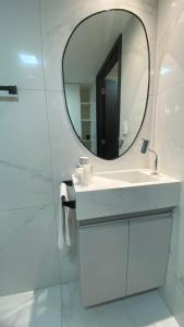une salle de bains avec un lavabo blanc et un miroir dans l'établissement Flat Move Tambaú, à João Pessoa