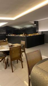 une salle à manger avec une table et des chaises et une cuisine dans l'établissement Flat Move Tambaú, à João Pessoa